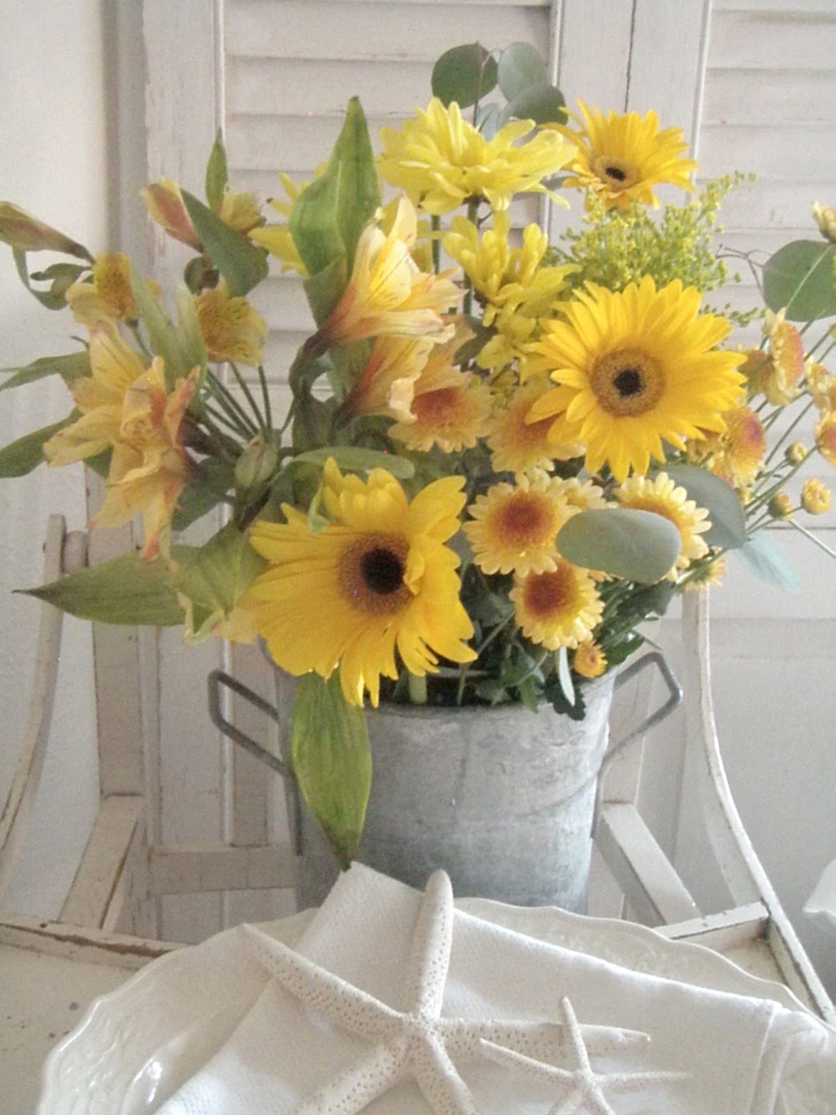 yellow flower arrangement in a vintage tin bucket