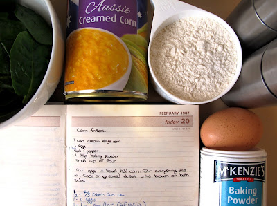 Handwritten recipe for corn fritters, surrounded by the ingredients needed to cook the recipe