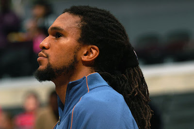 A black man with his natural hair braided