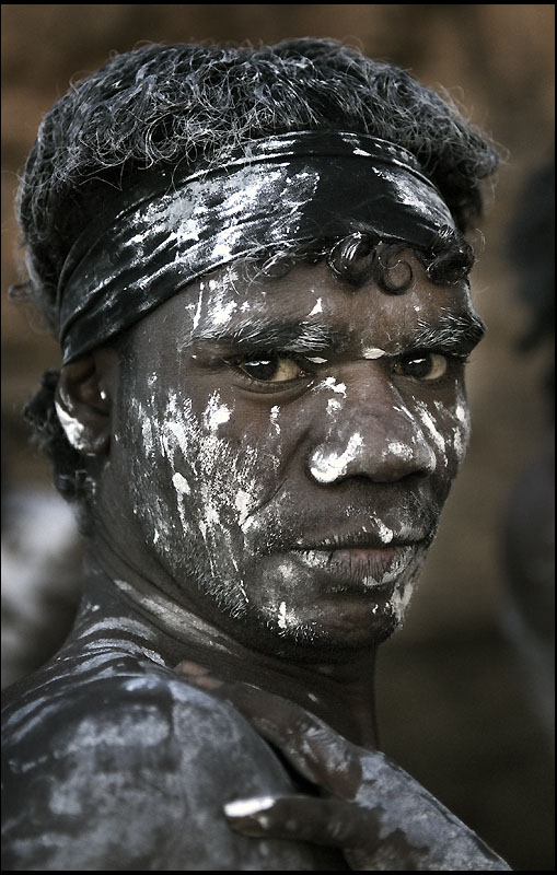A black man daubed in white body paint