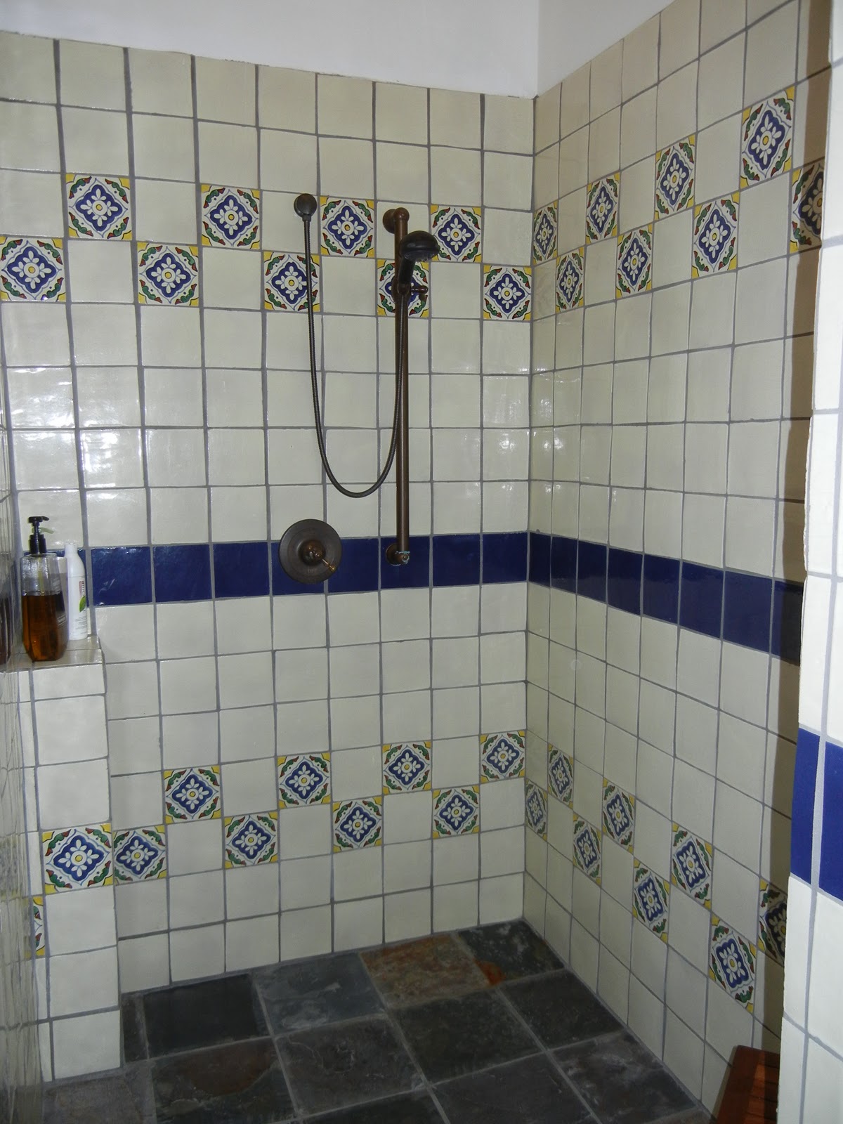 Talavera tiles line the walls of a simple walkin shower. Perfect for