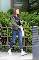 Mila Kunis in a pair of jeans and green grey jacket