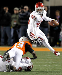 Wide receiver Ryan Broyles #85 of the Oklahoma Sooners leaps over cornerback Brodrick Brown #19 of the Oklahoma State Cowboys at Boone Pickens Stadium on November 27, 2010 in Stillwater, Oklahoma. The Sooners beat the Cowboys 47-41. (November 26, 2010 - Source: Tom Pennington/Getty Images North America)