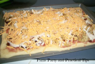 Adding the cheese on top of the leftover turkey pizza 