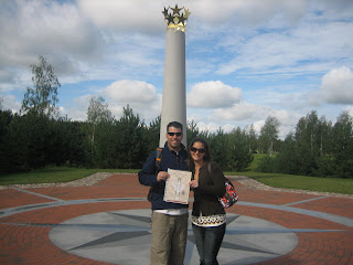 a man and woman posing for a picture in front of a monument