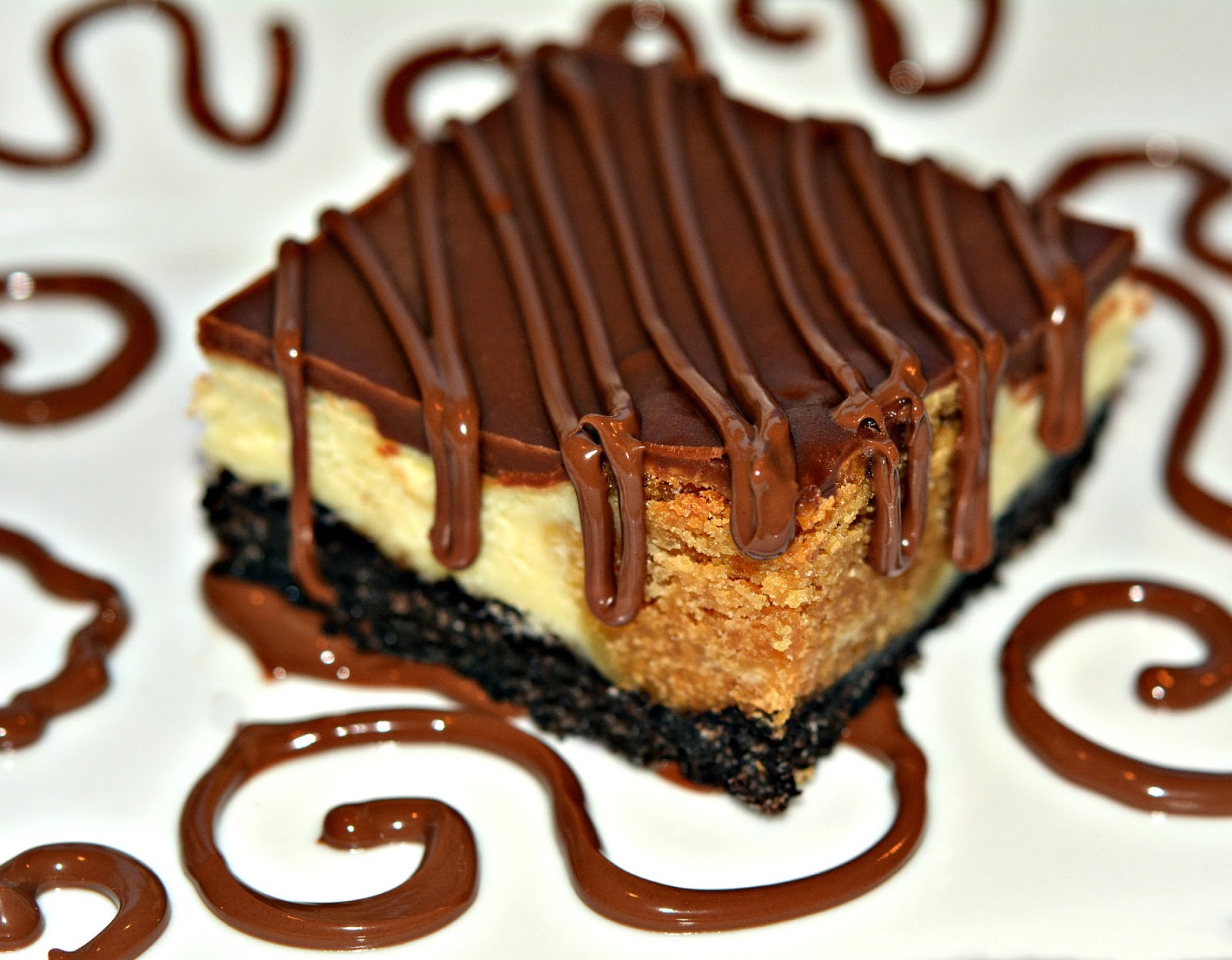 PEANUT BUTTER COOKIE DOUGH CHEESECAKE BARS ON AN OREO CRUST AND TOPPED WITH A MILK CHOCOLATE