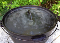 The rimmed lid on a Dutch oven holds coals on top of the oven.