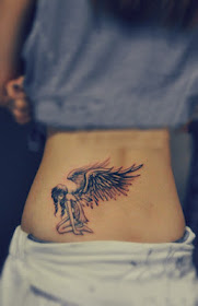 A tattoo featuring a girl with angel wings with her knees on the ground
