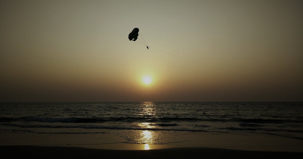 Parasailing Against The Back Drop Of Setting Sun.