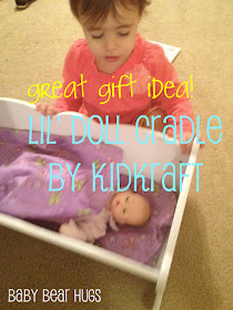 toddler with Kidkraft Lil' doll cradle