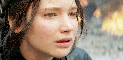 No gif: Um close do rosto abalado de Katniss quando ela fecha os olhos e cai uma lágrima.