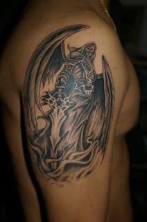 Death tattoo covering the shoulder and the upper arm: Grim Reaper portrayed as a winged skeleton