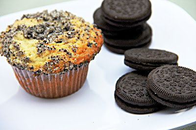 muffins with an oreo streusel on top and stacks of oreos next to it