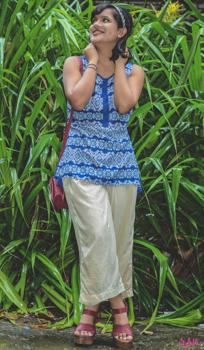 Wearing a Liva infused sheer blue printed tunic and cream culottes, Dayle Pereira of Style File India styles her personal style outfit with a Forever 21 burgundy sling bag, clogs, an embellished hairband and dark lips on a background of greenery in the monsoons as it rains 