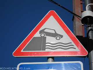 a road sign with a picture of a car on the side of the road