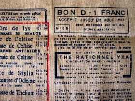 Close up of linen fabric printed with old french advertising in blue and red.