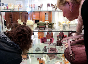 Customers browsing the displays of dolls' house miniatures at Fairy Meadow Miniatures.