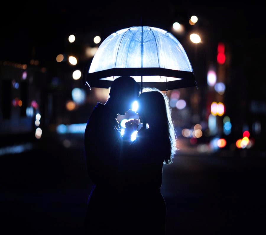 Pareja bajo paraguas una pareja de noche bajo un paraguas azul