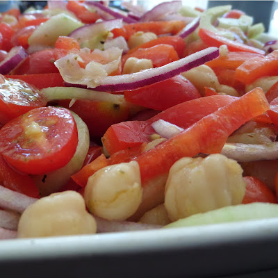 Greek Salad:  A fresh and delicious salad with tomatoes, cucumber, red onion, red bell pepper, and garbanzo beans tossed in a lemon and oregano dressing. 