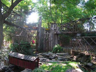 Model train bridges made of large twigs, with rocks and waterfalls