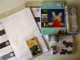 Selection of craft items including scrapbooking paper, fabric, washi tape, charms and a book.