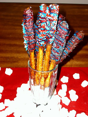 Chocolate Caramel Dipped Pretzels standing in a glass with red, white and blue sprinkles