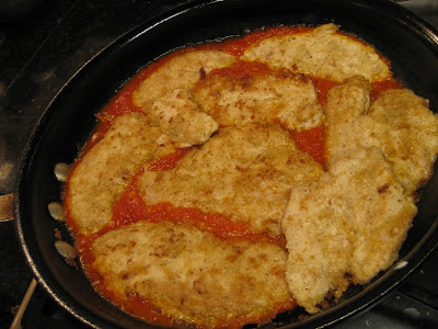 chicken with tomato sauce cooking in pan