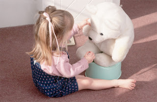  Изображение девочки, которая приучает плюшевого мишку к горшку