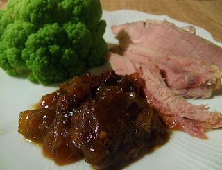 Plate with Chutney in front of turkey slices and green cauliflower