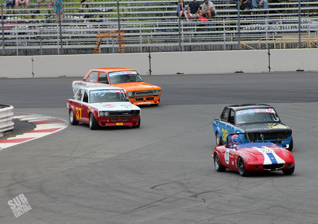 A Lotus Elan and several Datsun 510 race cars at PIR