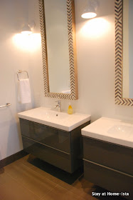 Modern grey and white bathroom with Ikea vanities and herringbone mirrors