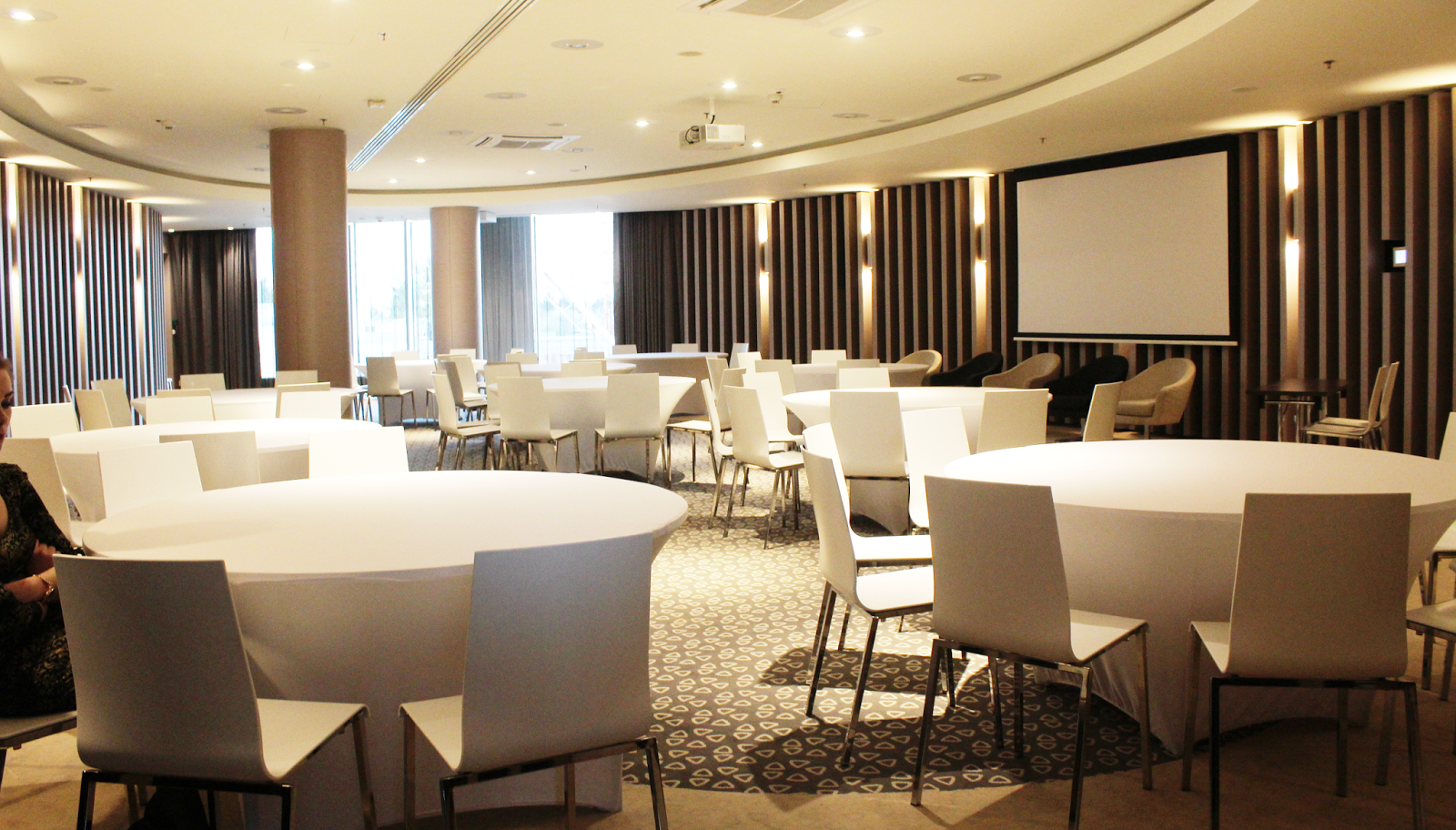 okrągły stół, białe krzesła w sali konferencyjnej,designerskie wnętrze hotelu