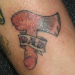tatuaje de un hacha con mango de pene que dice: papá