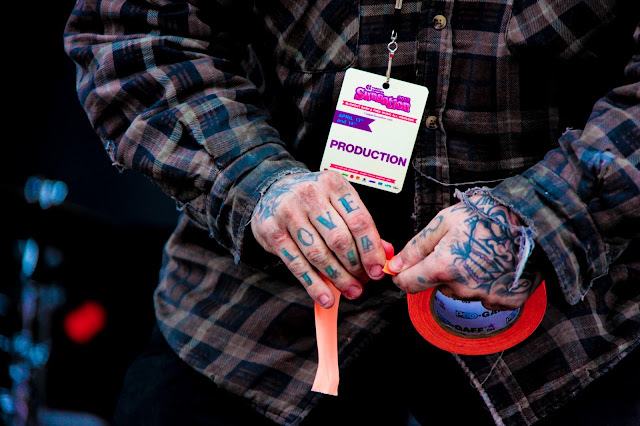 A guy with a tattoo on each of his fingers that spell out LOVE.