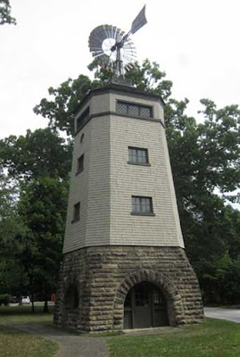 Craftsman-style windmill with cedar shake shingles, stone base