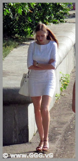 Slender young woman in tight white summer dress 