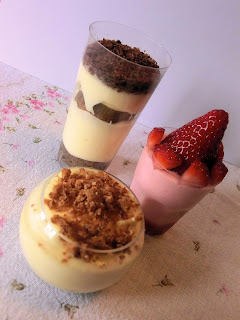 Finger-food dessert shooters trio with mascarpone and amaretto cream, tiramisu coffee mousse and strawberry and whipped cream mousse