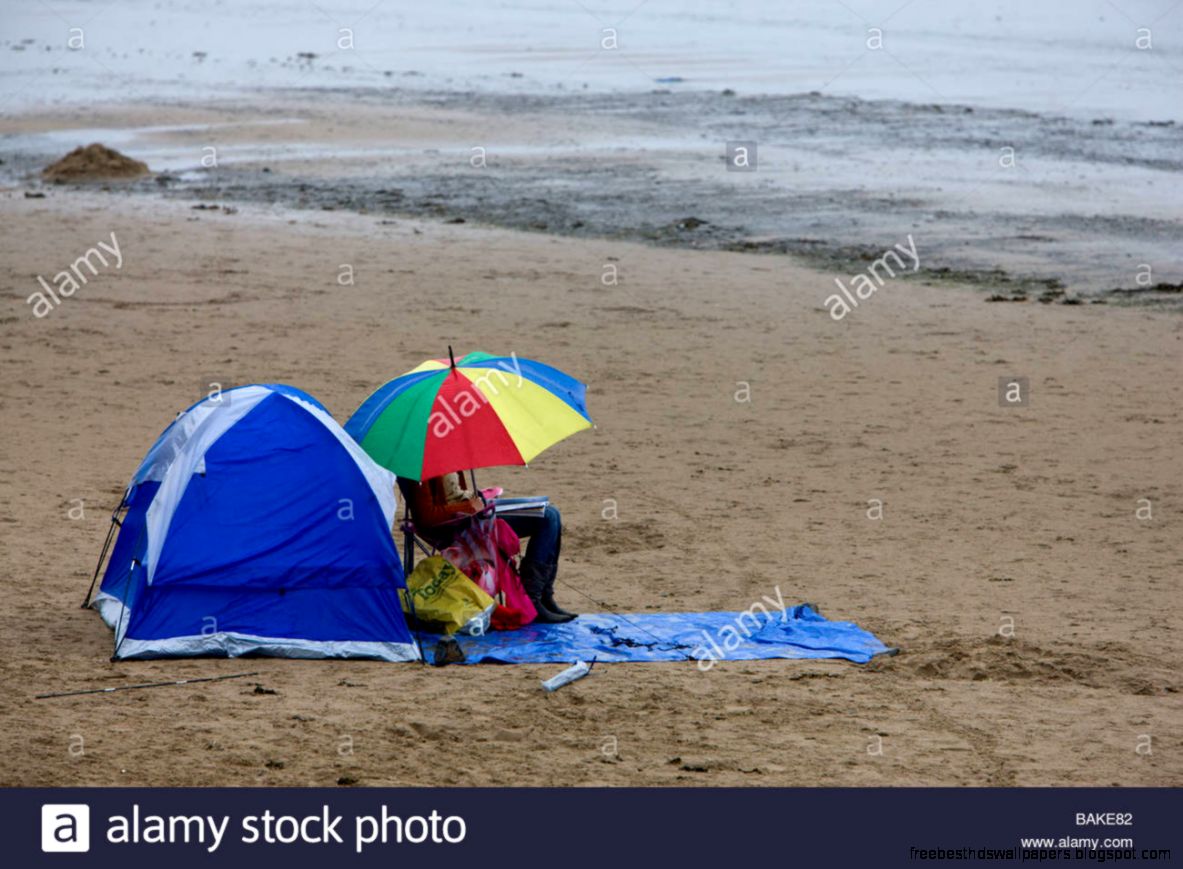 On Summer Holiday Sitting On The Beach Under An Umbrella On A Wet On Summer Holiday Sitting On The Beach Under An Umbrella On A Wet
