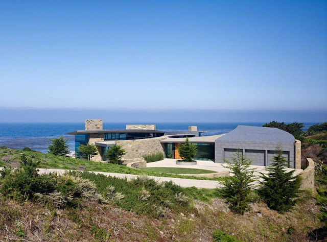 Picture of the modern house as seen from the land with the ocean on the background