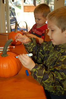 boys decorating pumpkins