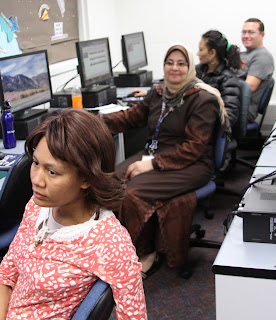 a row of teachers sit at computers