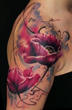 Kolorowy tatuaż kwiatów na ramieniu przechodzący na łopatkę