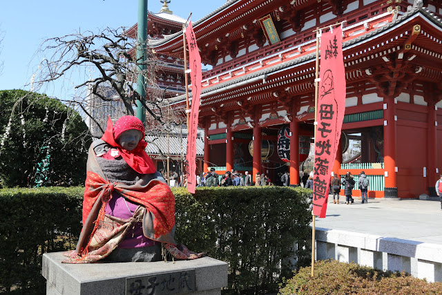The beautiful view of a statue which is wrapped with a red cloth in front of Hozomon Gate of the main temple's hall at Asakusa Sensoji Temple in Tokyo, Japan The beautiful view of a statue which is wrapped with a red cloth in front of Hozomon Gate of the main temple's hall at Asakusa Sensoji Temple in Tokyo, Japan