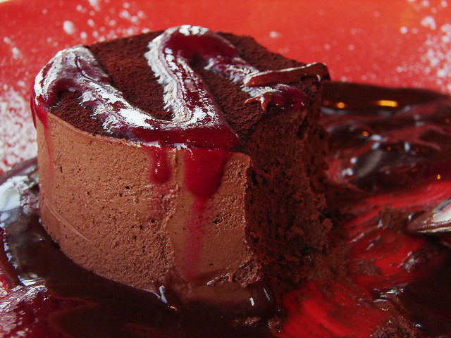 A thick, sauce-covered slice of chocolate mousse cake