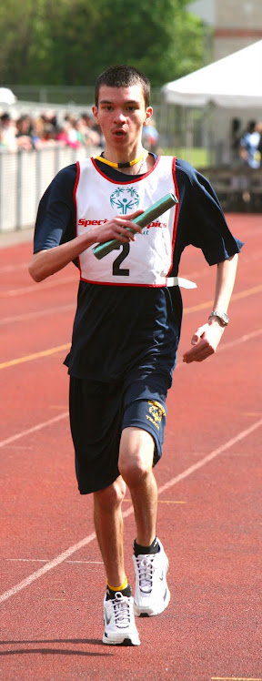 SPECIAL OLYMPICS ATHLETE FROM SIMSBURY COMPETES IN THE 4X400 M RELAY EVENT.