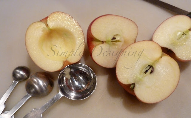 apple cut in half, with core removed using a metal tablespoon