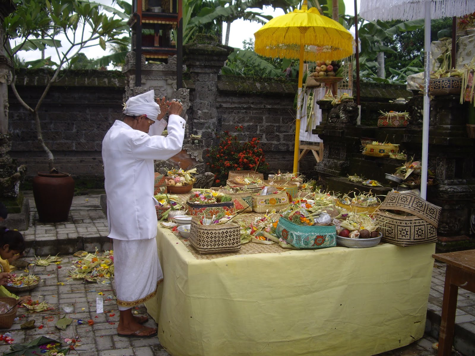 A VILLAGE PRIEST (PEMANGKU) BLESSES THE OFFERINGS BROUGHT TO THE TEMPLE