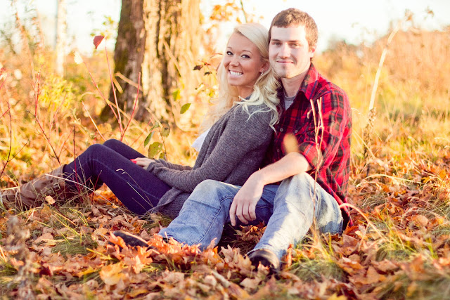 couple sitting in field in the fall