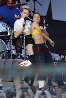 Miley Cyrus grinds against her back up dancer