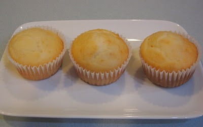 three unfrosted yellow cupcakes on white plate